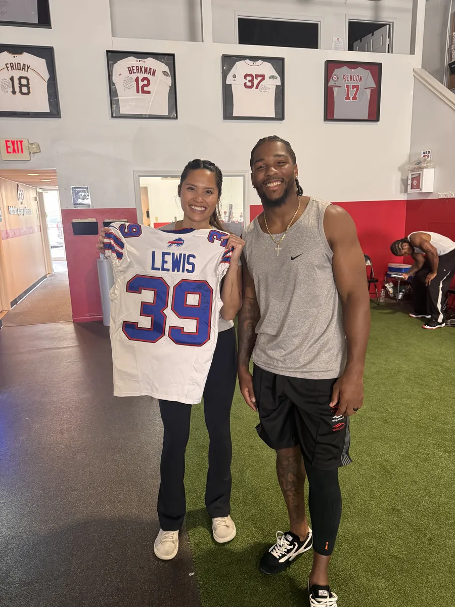 Cam Lewis holding his game jersey with a Unify PT clinician