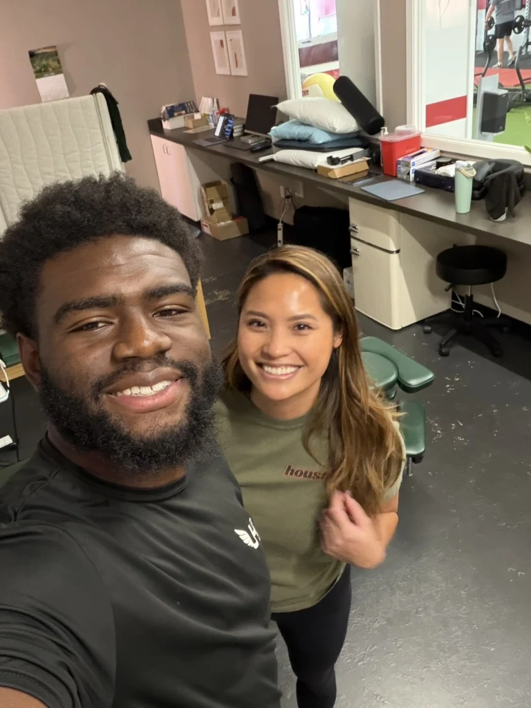 Athlete smiling with a Unify PT clinician inside the clinic