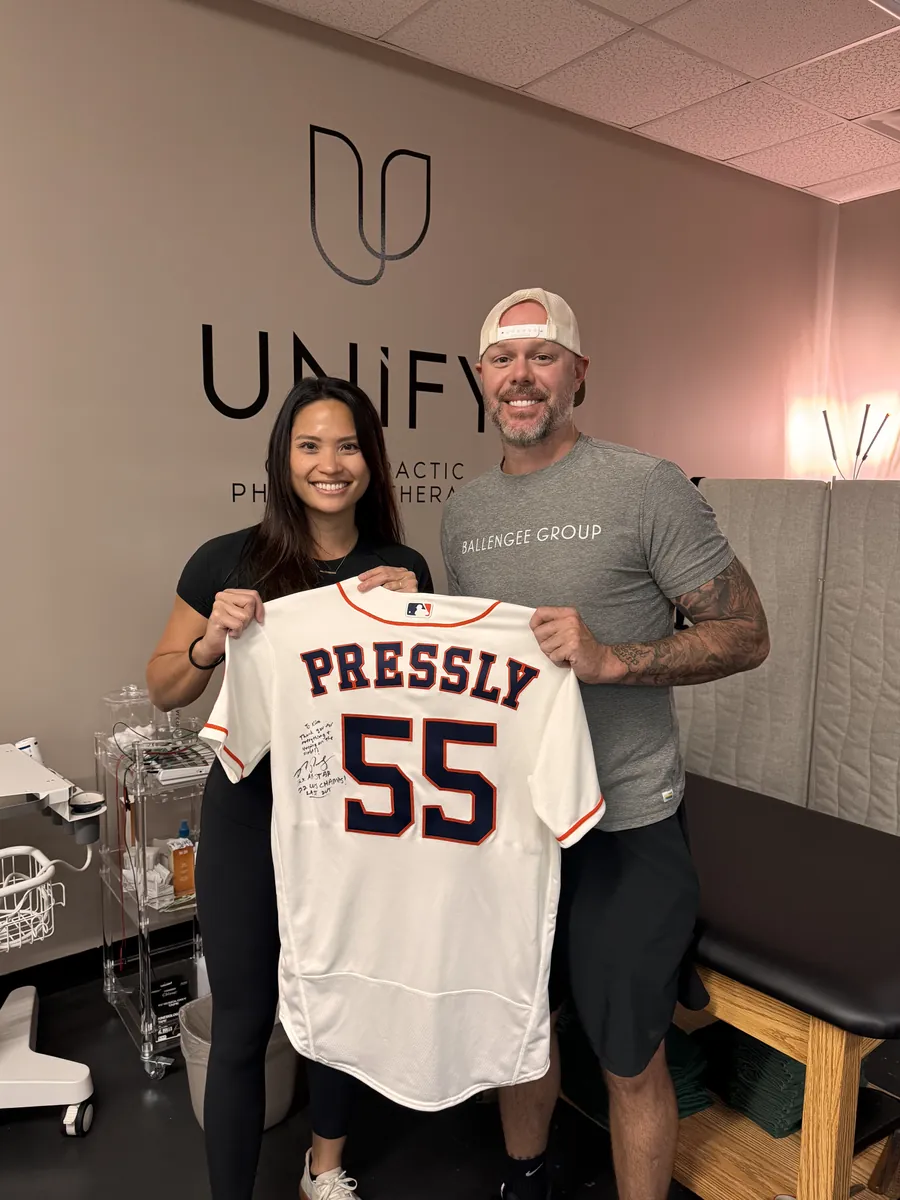 Ryan Pressly holding his signed jersey inside the Unify PT clinic