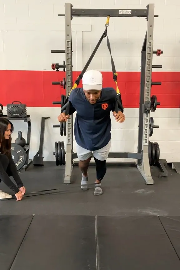 Athlete training with suspension straps and band resistance during a Unify PT session